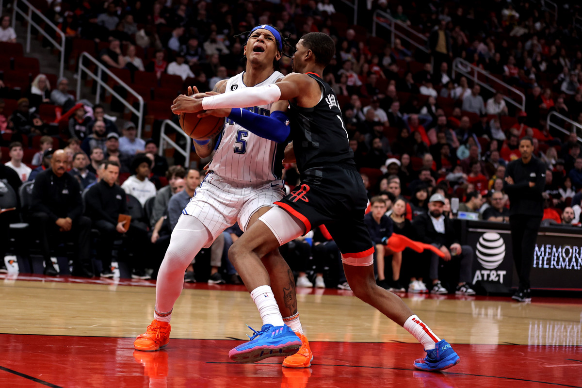 Orlando Magic forward Paolo Banchero (5) wrestles for the ball with Houston Rockets forward Jabari Smith Jr. (1)